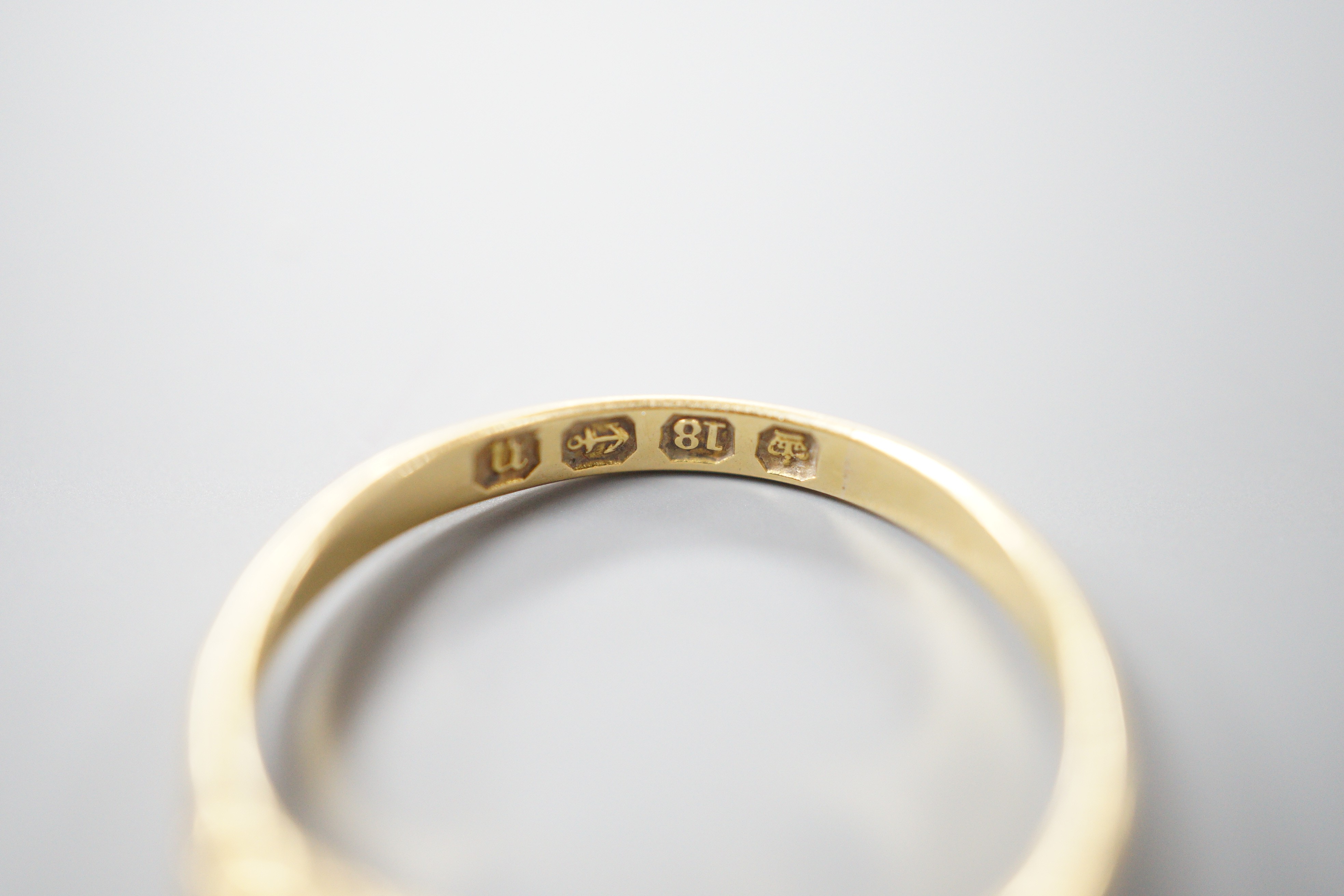 A late Victorian 18ct gold and graduated claw set five stone diamond half hoop ring, size N, gross weight 2.5 grams.